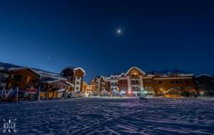 a town in the snow at night with the moon at New Gudauri M&N in Gudauri