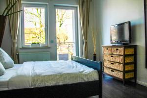 een slaapkamer met een bed en een televisie op een dressoir bij EXKLUSIVE 2 Zimmer Wohnung mit Balkon in Top Lage! in Bremen