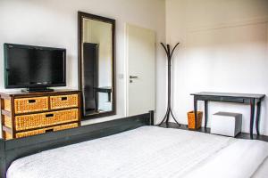 a bedroom with a bed and a tv and a mirror at EXKLUSIVE 2 Zimmer Wohnung mit Balkon in Top Lage! in Bremen