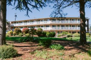 an apartment building with trees in front of it at Riverfront Inn Roseburg in Roseburg