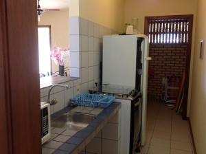 a kitchen with a sink and a refrigerator at Praia Brava Apto 2 dorms Vista ao Mar in Florianópolis +252 photos