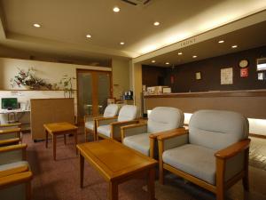 una sala de espera con una fila de sillas y mesas en Hotel Route-Inn Yokkaichi, en Yokkaichi