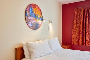 a bedroom with a bed with a painting on the wall at Coastal Spacious Mountain Views in Kaikoura