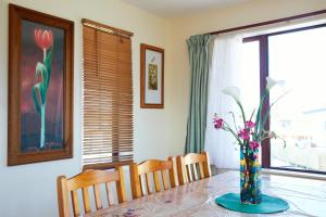 a dining room table with a vase of flowers on it at Coastal Spacious Mountain Views in Kaikoura