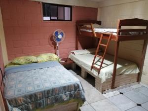 Cette chambre comprend 2 lits superposés et une chaise. dans l'établissement Casa Hospedaje Playas, à Playas