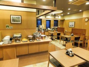 una sala da pranzo con tavoli e sedie e un ristorante di Hotel Route-Inn Toyokawa Inter a Toyokawa