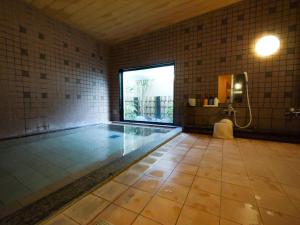 una grande piscina in una stanza con finestra di Hotel Route-Inn Toyokawa Inter a Toyokawa