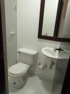 a white bathroom with a toilet and a sink at Cabaña Ciudadela Premium San Jeronimo in San Jerónimo