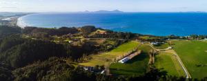 an aerial view of a golf course next to the ocean at Country Homestead at Black Sheep Farm in Waipu