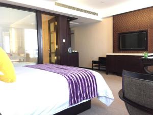 杭州的住宿－杭州西溪谷君亭酒店，配有一张床和一台平面电视的酒店客房