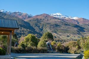 a house with a mountain in the background at Wonderland Makarora Lodge in Makarora