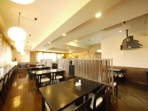 jadalnia ze stołami i krzesłami w restauracji w obiekcie Hotel Route-Inn Iida w mieście Iida