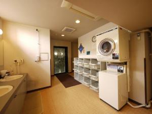 un bagno con lavatrice e asciugatrice a parete di Hotel Route-Inn Iida a Iida