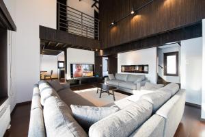 a living room with a large couch and a tv at La Plagne in Kutchan