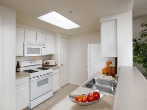 a kitchen with white cabinets and a bowl of fruit on the counter at National at Courthouse Place in Arlington
