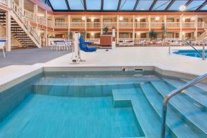 a pool in a large building with a swimming pool at AmericInn by Wyndham Janesville in Janesville