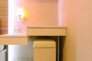 a desk in a room with a stool under it at Best Price 1BR Apartment at The Oasis Cikarang By Travelio in Cikarang
