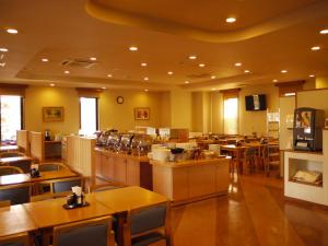 a restaurant with wooden tables and chairs and a cafeteria at Hotel Route-Inn Shin Gotemba Inter -Kokudo 246 gou- in Gotemba