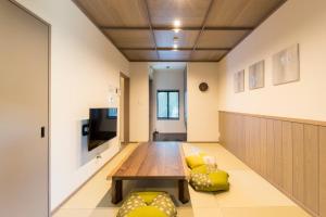um quarto com uma mesa, um sofá e uma televisão em 博多町家ホテル - Kamigofuku - em Fukuoka