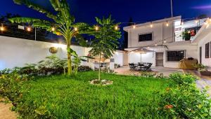 un patio trasero de una casa por la noche con luces en Vacation Rental - Standard Room at Casa Cocoa, en Cozumel