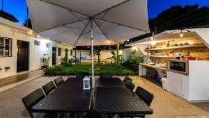 une terrasse avec une table et un parasol dans l'établissement Vacation Rental - Standard Room at Casa Cocoa, à Cozumel