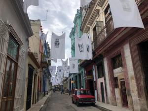 an alley with flags and a red car on a street at Muralla suite 320. Habana Vieja in Havana
