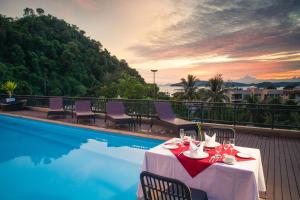 a table on a balcony with a view of a pool at Navinda Krabi - SHA Plus in Ao Nang Beach