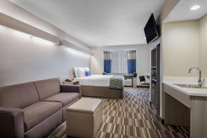 a hotel room with a bed and a couch at Microtel Inn & Suites by Wyndham Atlanta Buckhead Area in Atlanta