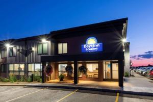 a building with a sign that reads dossin and smiles at Days Inn & Suites by Wyndham Duluth by the Mall in Duluth