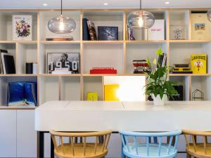 a kitchen with a white counter and four chairs at ibis Genève Petit Lancy in Geneva