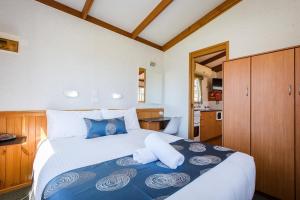a bedroom with a large bed with blue and white pillows at Discovery Parks - Lake Hume, New South Wales in Lake Hume +13 photos
