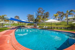 a large blue swimming pool with umbrellas at Discovery Parks - Lake Hume, New South Wales in Lake Hume