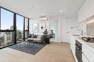 a kitchen and living room with a couch and a table at Luxuria Apartments - Avant in Melbourne