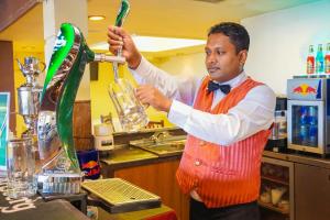 Een man die een drankje in een blender giet. bij Grand Oriental Hotel in Colombo