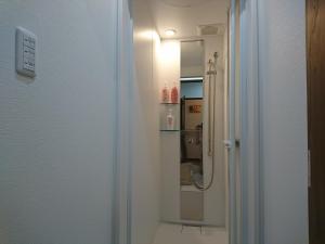 y baño con ducha y espejo. en Guesthouse Hajimari, en Kashihara