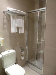 a bathroom with a toilet and a glass shower at Hotel 4C Puerta Europa in Madrid