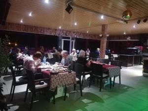 a group of people sitting at tables in a restaurant at Hotel Grün in Kızılot