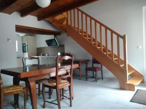 a dining room with a table and chairs and a staircase at Gîte de La Basse Roche in Sougé