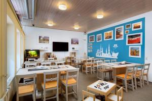 a classroom with tables and chairs and a flat screen tv at KNAUS Campingpark Hamburg in Hamburg