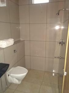 a bathroom with a toilet and a glass shower at Shamrock Holiday Home in Munnar