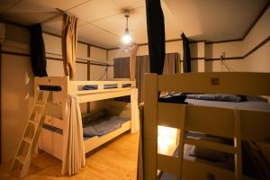 a room with two bunk beds and a ladder at Guesthouse Banvina in Kagoshima