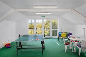 ヒューンフェルトにあるKNAUS Campingpark Hünfeldの卓球台と椅子が備わる客室です。