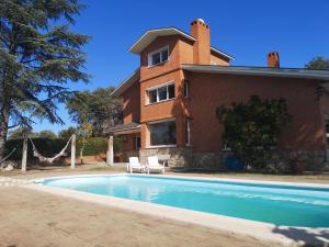 比利亚维西奥萨-德奥东Madrid Green的一栋房子前面有游泳池