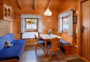 uma sala de jantar com uma mesa e um sofá azul em Knaus Campingpark Lackenhäuser em Neureichenau