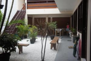a courtyard with benches and potted plants in a building at Pousada das Gaivotas in Bombinhas +17 photos
