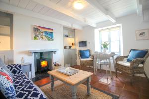 a living room with a couch and a fireplace at Chapel Cottage in Saint Mawes