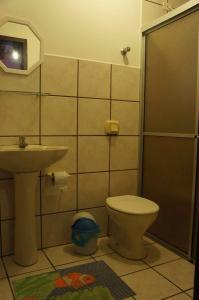 a bathroom with a toilet and a sink at Pousada das Gaivotas in Bombinhas