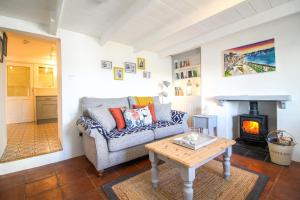a living room with a couch and a wood stove at Chapel Cottage in Saint Mawes