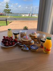 a table with a plate of food and fruit and juice at Boat Harbour Jetty B&B in Port Albert
