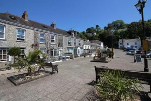 a town square with two benches and buildings at The Customs House in St Austell